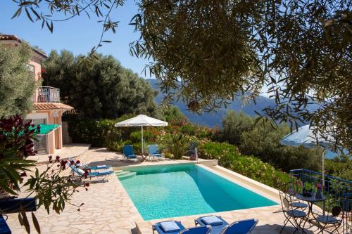 a swimming pool in a yard with chairs and an umbrella at Villa Evalin - Pretty Villa Like at Home for Unforgettable Holidays in Sivota