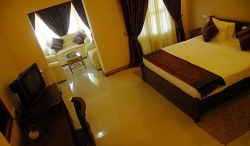 a hotel room with a bed and a television at Vintara Eco Resort in Hambantota