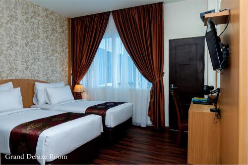 Grand Bayu Hill Hotel في Takengon: غرفة فندقية بسريرين ونافذة
