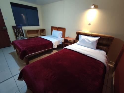 Habitación de hotel con 2 camas con sábanas rojas en Casa particular, en Arequipa