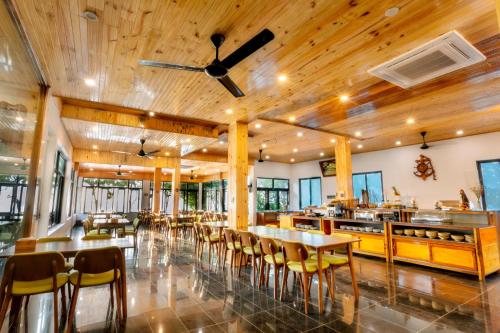 ein Restaurant mit Holzdecken, Tischen und Stühlen in der Unterkunft Palm Beach Hotel Phú Yên 