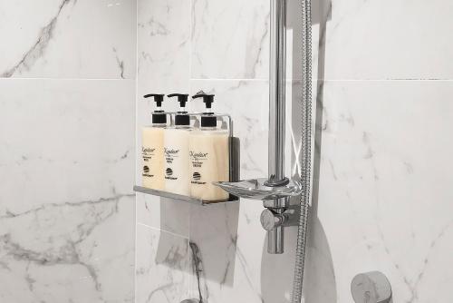 a bathroom with a shower with two shampoo bottles at ILLUME Taipei in Taipei