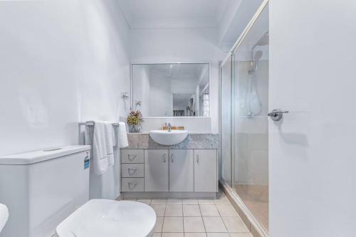 een witte badkamer met een toilet en een wastafel bij Baydream on Whisper in Cannonvale