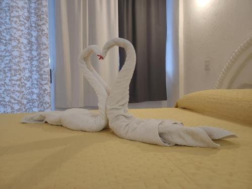 two towelsrendered to look like swans on a bed at Lovely studio apartment with balcony AC & wi-fi, minutes from downtown! in Zihuatanejo