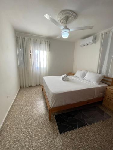 a bedroom with a bed and a ceiling fan at Apartamento calido in Santo Domingo