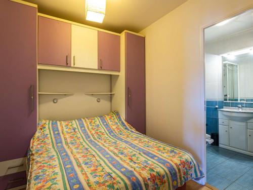 um quarto com uma cama com um cobertor colorido em Appartement Hendaye, 1 pièce, 2 personnes - FR-1-2-421 em Hendaye