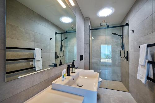 uma casa de banho com um lavatório e um chuveiro em On The Edge em Kaikoura