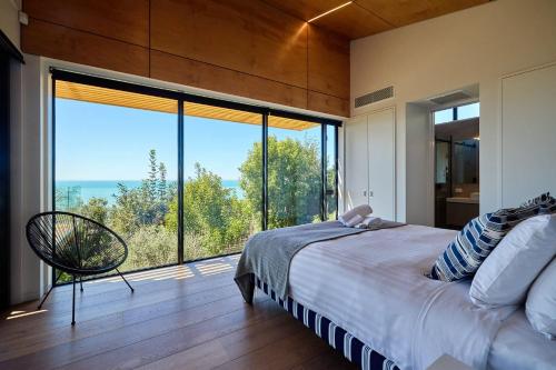 um quarto com uma cama e uma grande janela em On The Edge em Kaikoura