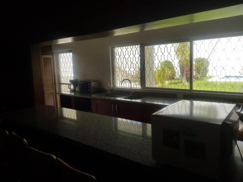 a kitchen with a counter top and a window at Casa Cuernavaca con alberca en fraccionamiento in Cuernavaca