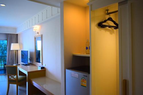 a room with a desk and a table with a refrigerator at Seapine Beach Golf and Resort Hua Hin in Hua Hin