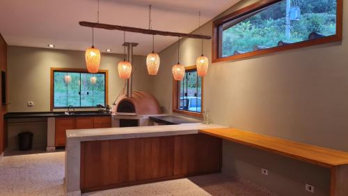 a kitchen with a counter and some windows at Espaço Canto in Santo Antônio do Pinhal