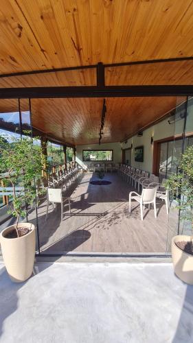 a large room with white chairs and a wooden ceiling at Espaço Canto in Santo Antônio do Pinhal