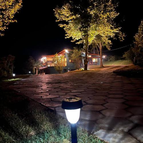 a street light in the middle of a driveway at night at Espaço Canto in Santo Antônio do Pinhal