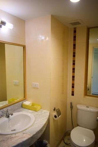 a bathroom with a sink and a toilet and a mirror at Seapine Beach Golf and Resort Hua Hin in Hua Hin