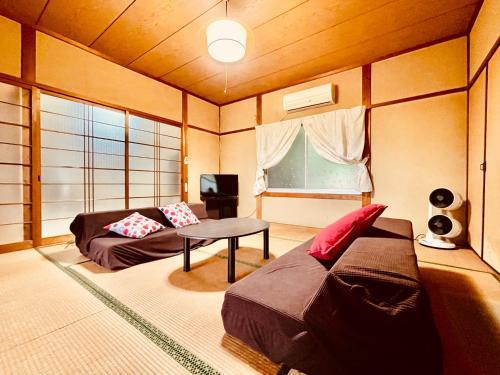 ein Wohnzimmer mit einem Sofa und einem Tisch in der Unterkunft ワイルドライフ　森風 in Hiki