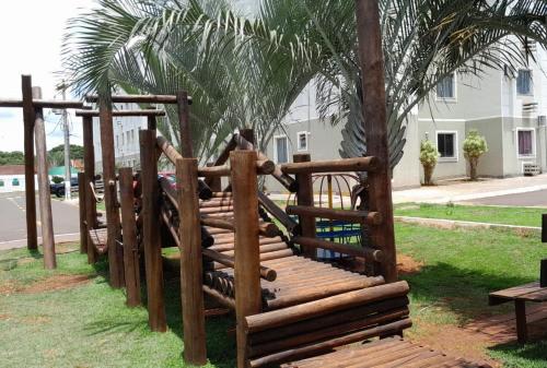 a wooden playground in a park next to a palm tree at 4 ESTAÇÕES - apto em condomínio - 2 quartos com ar condicionado in Campo Grande