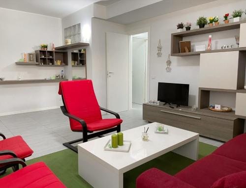 阿齊·卡斯特羅的住宿－Reef house，客厅配有红色椅子和白色桌子