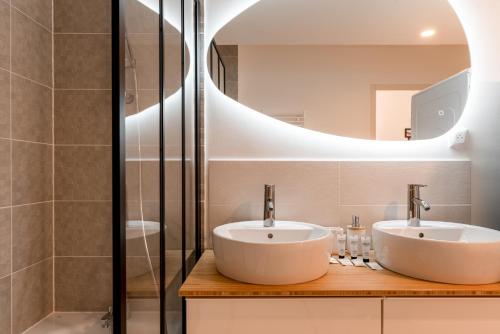 een badkamer met 2 wastafels en een spiegel bij Rouen, Seine View in Rouen