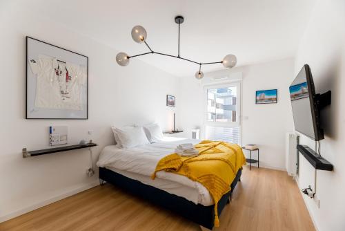 ein Schlafzimmer mit einem Bett mit einer gelben Decke darauf in der Unterkunft Rouen, Seine View in Rouen