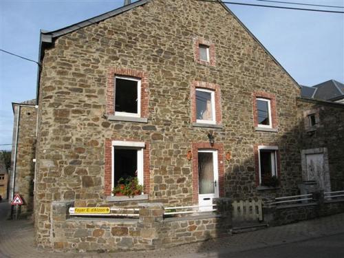 an old stone building with windows on a street at Les Bucherons in Awenne