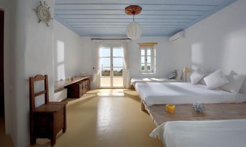 a bedroom with two beds and a clock on the ceiling at Villa Karam in Mikonos