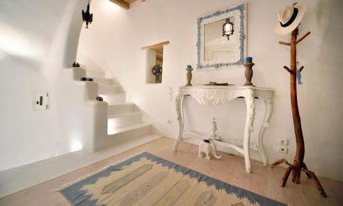 Habitación blanca con mesa blanca y escaleras en Villa Karam en Mykonos