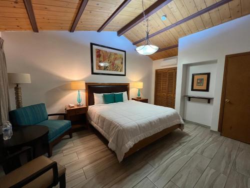 a bedroom with a bed and a couch and a chair at Hotel Casa del Sol in Ensenada