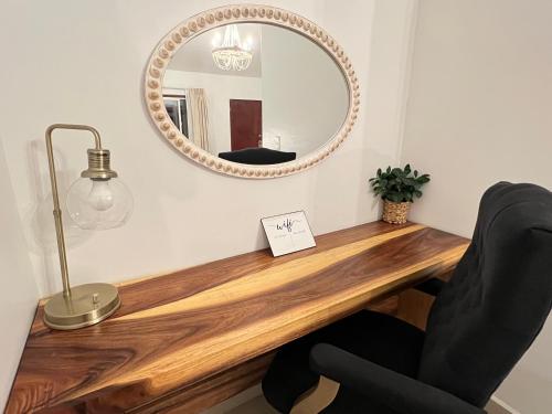 a mirror on a wall above a desk with a chair at Hotel Casa del Sol in Ensenada