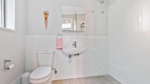 a white bathroom with a toilet and a sink at 'Little Mermaid' 28 Mermaid Avenue Hawks Nest in Hawks Nest