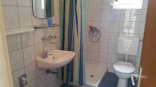 een kleine badkamer met een wastafel en een toilet bij Apartments Mat - 100 m from sea in Srima