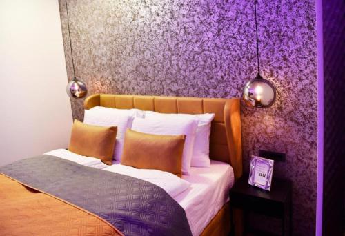 ein Schlafzimmer mit einem Bett mit einer lila Wand in der Unterkunft Apartment Turbo - with terrace, AC & WiFi in Zaprešić