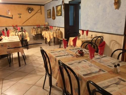 jadalnia ze stołami i krzesłami z czerwonymi serwetkami w obiekcie Aux Quatre Vents w mieście Saulieu