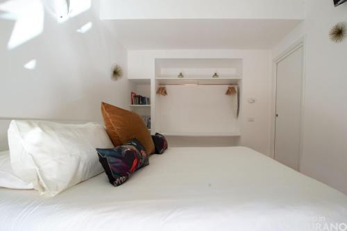 a bedroom with a white bed with pillows on it at MURANO Place - FILIGRANA House in Murano