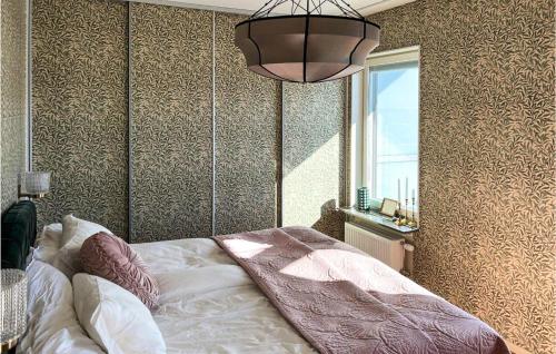1 dormitorio con cama, ventana y lámpara de araña en Pet Friendly Apartment In Uppsala With Kitchen en Uppsala