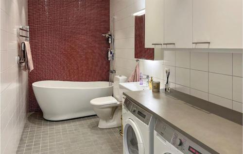 y baño con bañera, aseo y lavadora. en Pet Friendly Apartment In Uppsala With Kitchen en Uppsala