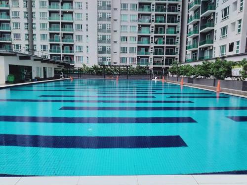 a large swimming pool in front of tall buildings at English Homestay Seaview Johor Bahru Permas 6 pax in Masai