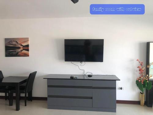 a living room with a table and a tv on a wall at View Talay6 by Blue Ocean Suite in Pattaya Central