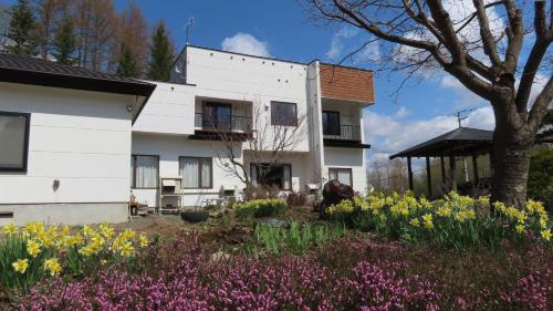 Casa blanca con jardín de flores en Coro Coro, en Biei