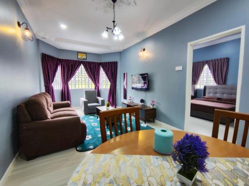 a living room with a couch a table and a bedroom at A ONE Holiday Apartment in Tanah Rata