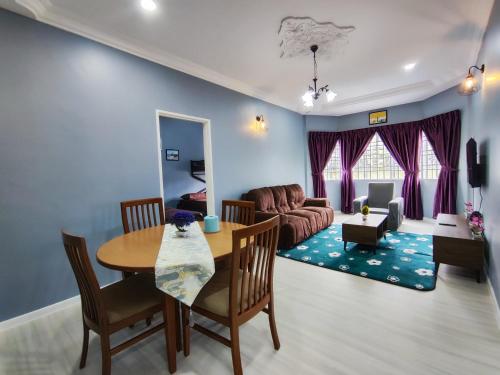 uma sala de estar com uma mesa e um sofá em A ONE Holiday Apartment em Tanah Rata