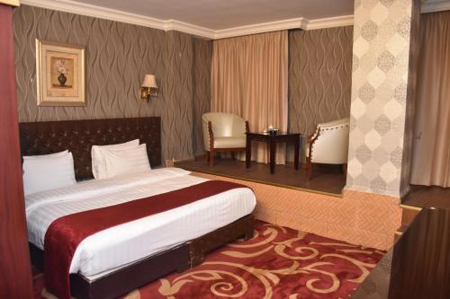 a hotel room with a bed and a table and chairs at Madison Hotel in Amman