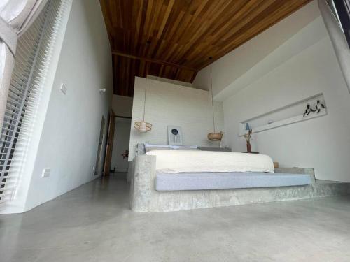 een slaapkamer met een groot bed en een houten plafond bij Villa Nour - 3 BR sea view pool villa in Srithanu in Srithanu