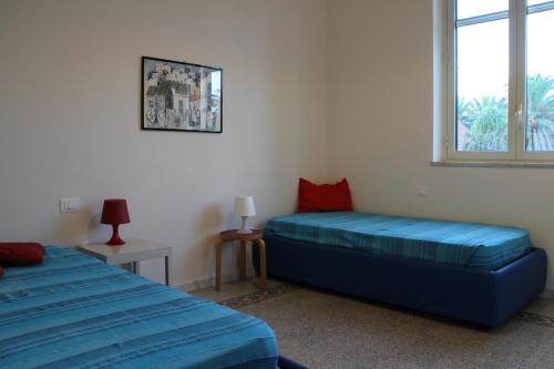 a bedroom with two beds and a window at La sirena sul mare di Mondello in Mondello