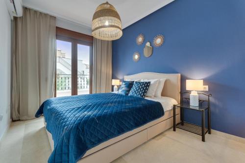 um quarto azul com uma cama e uma parede azul em soleadore sol em Orihuela