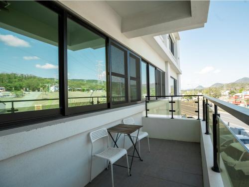 a balcony with a table and chairs in a building at 25Inn Hengchun Kenting in Nanwan