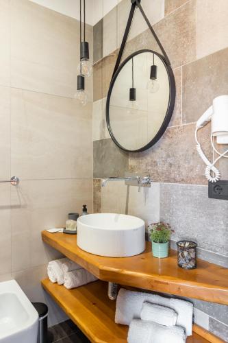 a bathroom with a sink and a mirror at Old Rooms in Quartu SantʼElena