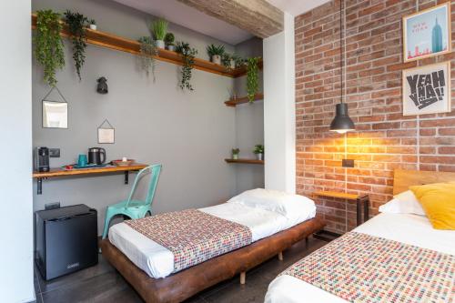 a bedroom with two beds and a brick wall at Old Rooms in Quartu SantʼElena