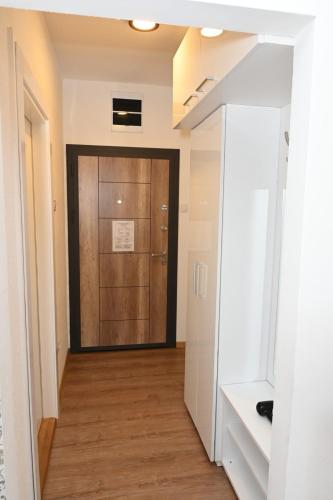 a hallway with a wooden door in a building at Apartman Krinka in Vrnjačka Banja
