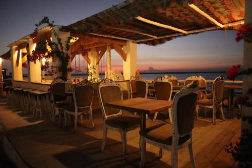 restauracja z krzesłami i stołem oraz ocean w obiekcie Banan Beach w mieście Ras al-Chajma