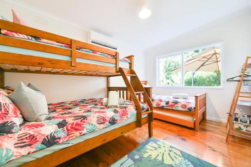 a bedroom with two bunk beds and a window at Beach Cottage. 100m to the beach 9minutes to Hot Springs. Pet Friendly in Capel Sound